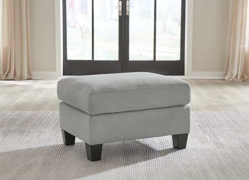 Ashley Furniture Adlai Ottoman in neutral fabric with a cushioned top and wooden block legs, versatile for living room decor.
