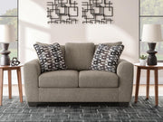 Ashley Furniture Triston-Peaks loveseat with plush fabric, cushioned seats, and rolled arms in a cozy, inviting living room setting.