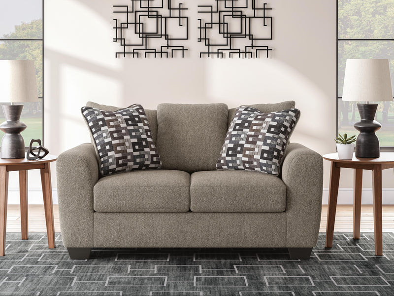 Ashley Furniture Triston-Peaks loveseat with plush fabric, cushioned seats, and rolled arms in a cozy, inviting living room setting.
