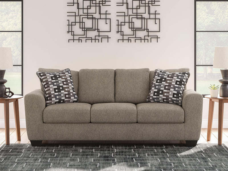 Ashley Furniture Triston-Peaks sofa with plush fabric and cushioned armrests in a modern living room setting.