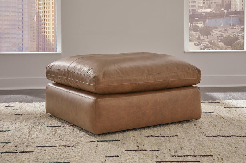 Emilia oversized accent ottoman by Ashley Furniture, upholstered in neutral fabric, with plush cushioning and wooden legs.