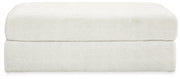 Ashley Furniture Karinne oversized accent ottoman with plush fabric and tufted top, shown in a neutral color.