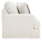 Ashley Furniture Karinne Loveseat with plush fabric and cushioned armrests, shown in a cozy living room setting.