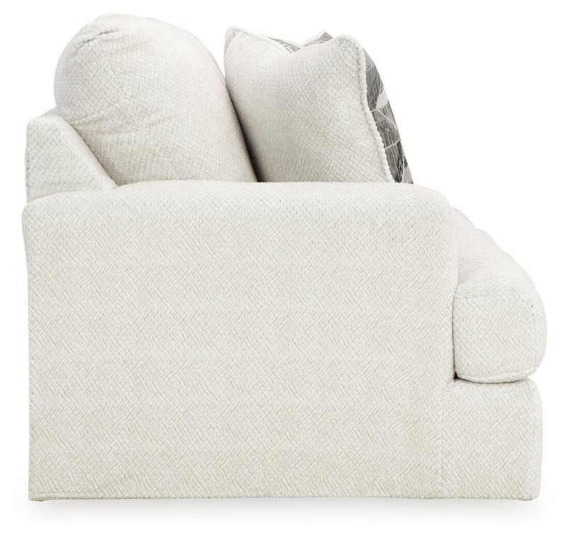 Ashley Furniture Karinne Loveseat with plush fabric and cushioned armrests, shown in a cozy living room setting.