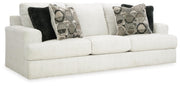 Ashley Furniture Karinne Sofa with plush fabric, angled view showing beige upholstery and modern design in a living room setting.