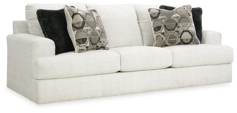 Ashley Furniture Karinne Sofa with plush fabric, angled view showing beige upholstery and modern design in a living room setting.