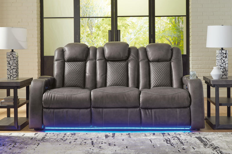 Ashley Furniture Fyne-Dyme power reclining sofa with plush cushions and dark fabric upholstery, shown in a closed reclining position.
