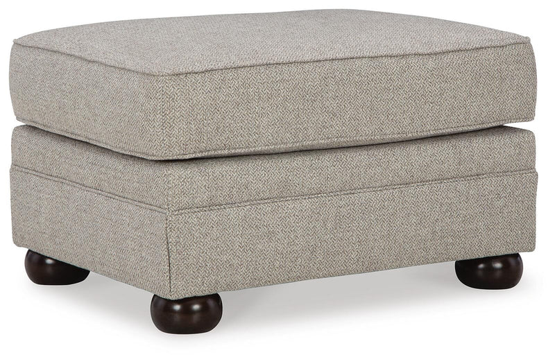 Ashley Furniture Gaelon Ottoman featuring a plush fabric surface and wooden legs, viewed from an angled perspective.