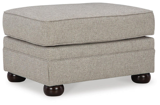 Ashley Furniture Gaelon Ottoman featuring a plush fabric surface and wooden legs, viewed from an angled perspective.