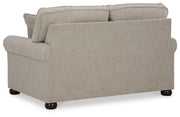 Ashley Furniture Gaelon loveseat with plush cushions and wooden legs, shown from the back in a cozy living room setting.