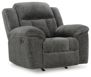 Ashley Furniture Frohn recliner in tan fabric, shown from an angle with closed footrest and cushioned armrests.