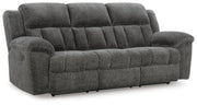 Ashley Furniture Frohn reclining sofa in dark upholstery, shown from an angled, closed position with plush cushions and wide armrests.
