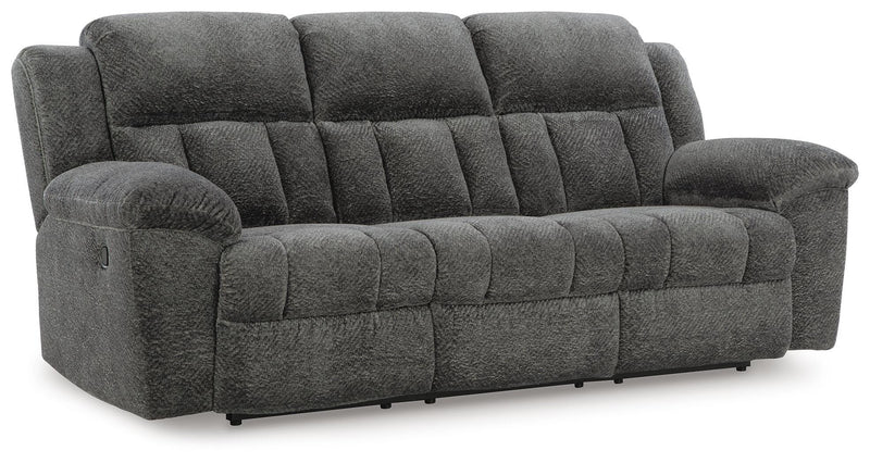 Ashley Furniture Frohn reclining sofa in dark upholstery, shown from an angled, closed position with plush cushions and wide armrests.