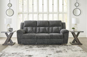 Ashley Furniture Frohn reclining sofa with plush cushions and soft fabric upholstery, shown in a closed reclining position.