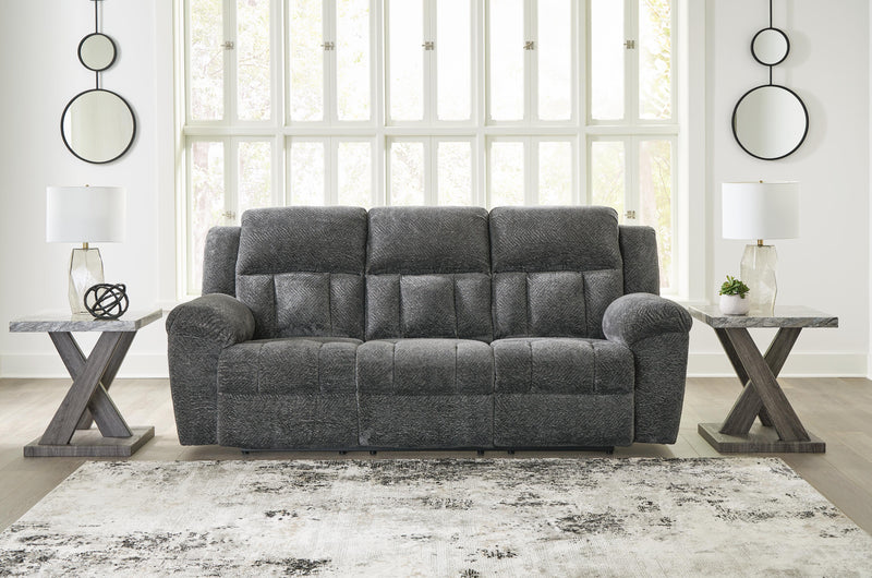 Ashley Furniture Frohn reclining sofa with plush cushions and soft fabric upholstery, shown in a closed reclining position.