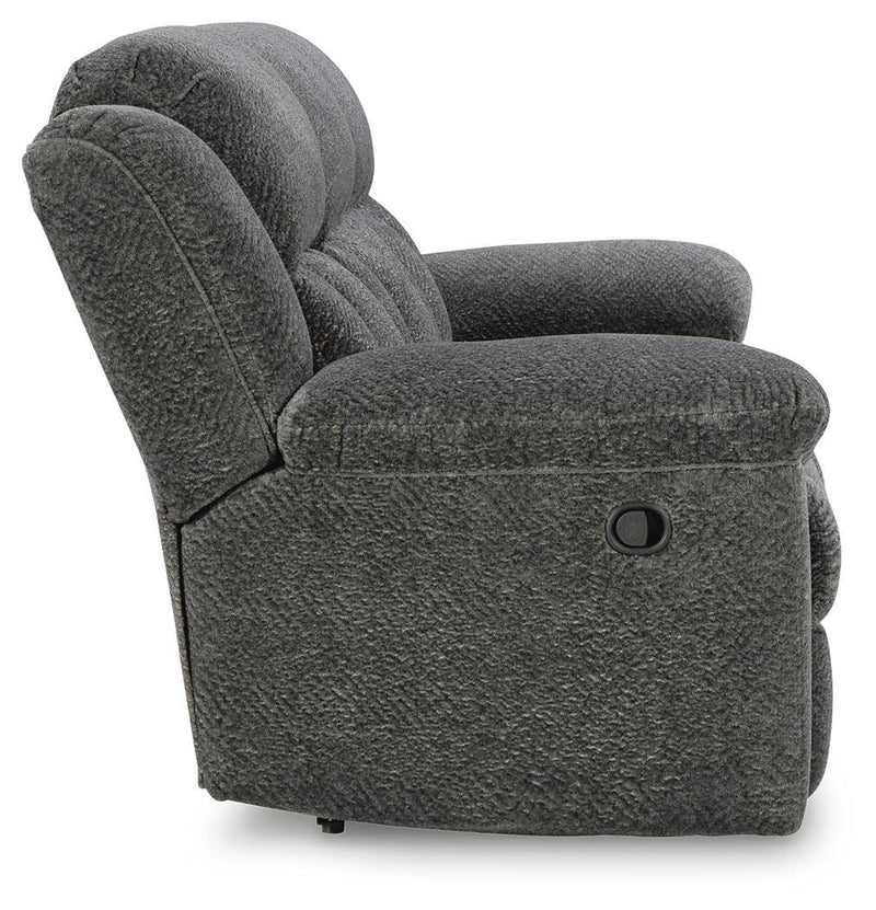 Ashley Furniture Frohn reclining sofa with plush cushions and reclining features, shown in a modern living room setting.