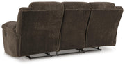 Ashley Furniture Frohn reclining sofa with plush fabric, padded armrests, and built-in recline feature in a modern living room setting.