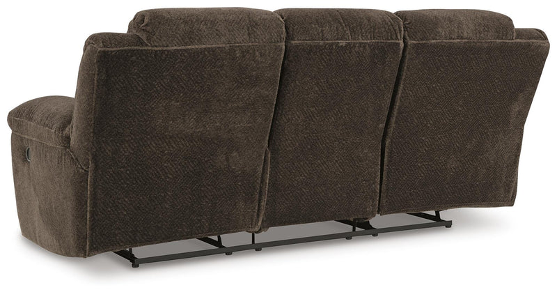 Ashley Furniture Frohn reclining sofa with plush fabric, padded armrests, and built-in recline feature in a modern living room setting.