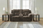Ashley Furniture Frohn reclining loveseat with built-in console, plush fabric, and cushioned armrests for comfortable seating.