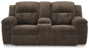 Ashley Furniture Frohn reclining loveseat with console, featuring plush fabric, padded armrests, and built-in cup holders.