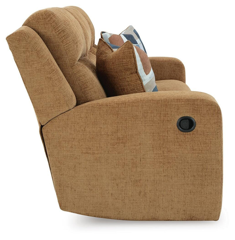 Ashley Furniture Kanlow reclining sofa with plush cushions and neutral fabric, shown from a side angle.