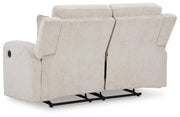 Ashley Furniture Danum reclining loveseat with plush fabric and padded armrests, shown in a comfortable, modern living room setting.