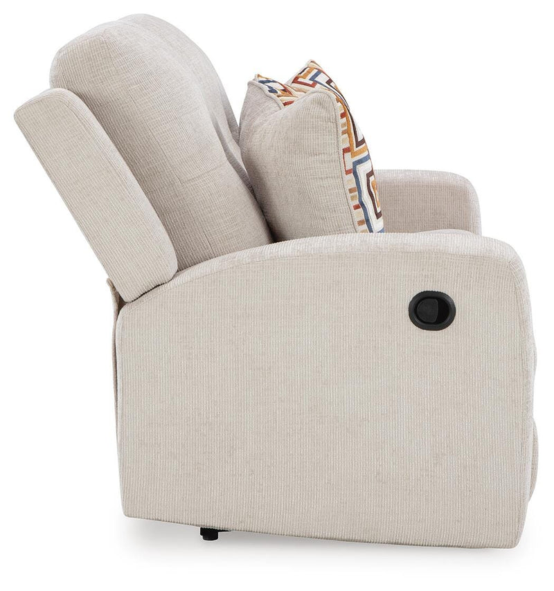 Ashley Furniture Danum reclining loveseat with plush fabric upholstery and padded armrests, shown in a cozy living room setting.