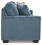 Ashley Furniture Cashton living room set featuring a sofa and loveseat with neutral upholstery and wooden legs.