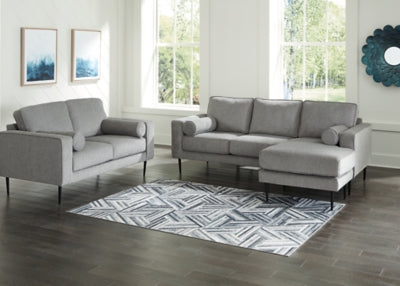 Ashley Furniture Hazela living room set with a sofa and matching armchair in a modern design, featuring neutral upholstery and wooden legs.
