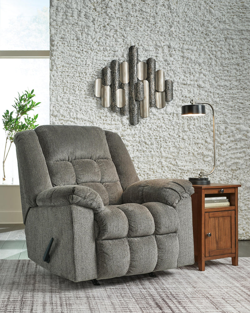Closed Ashley Furniture Kegler Recliner showing plush beige fabric, padded armrests, and a comfortable reclined design.