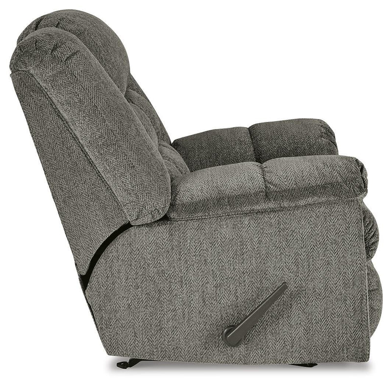 Ashley Furniture Kegler Recliner in beige fabric with plush cushioning and wide armrests, shown from side view.