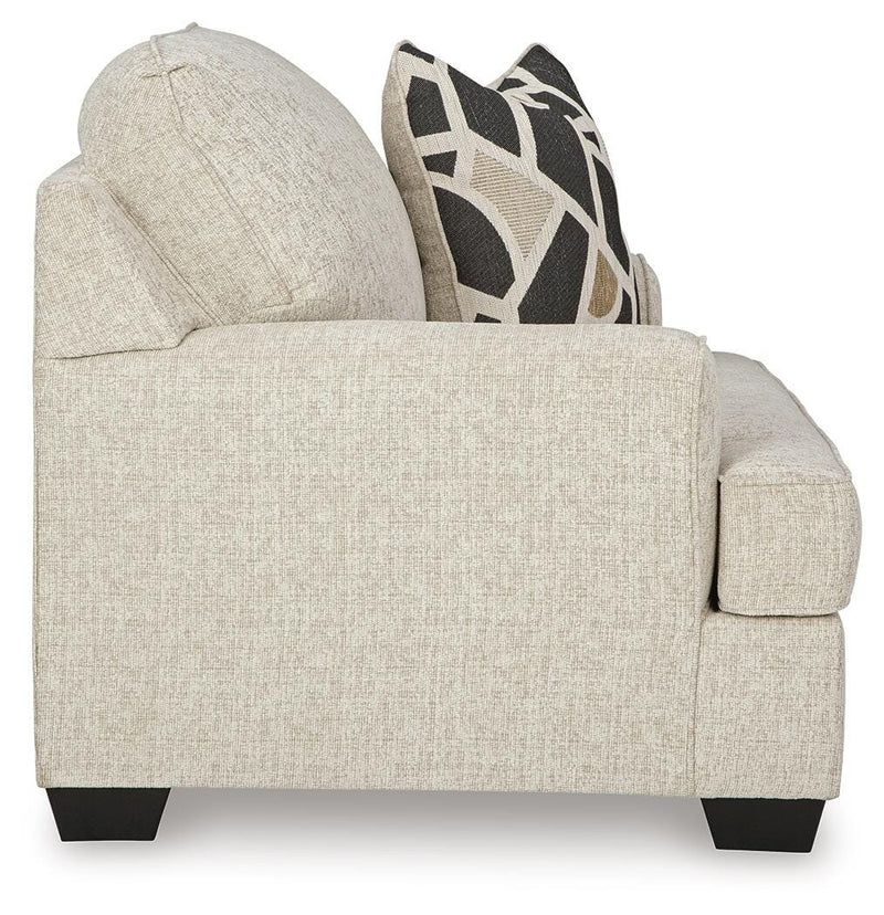 Ashley Furniture Heartcort oversized chair with plush upholstery and wide armrests, shown from the side in a modern living room setting.