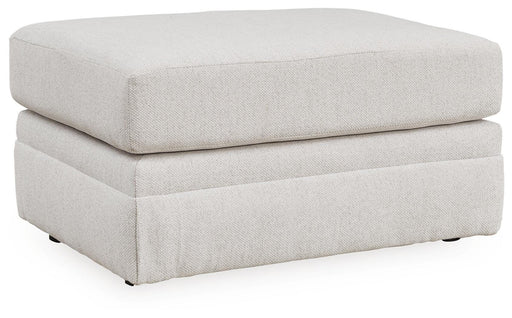 Ashley Furniture Maitelynn Ottoman in textured fabric, angled view showing sturdy wooden legs and plush cushioning.