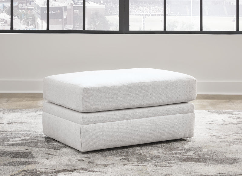 Ashley Furniture Maitelynn Ottoman with upholstered fabric and wooden legs, serving as a stylish and functional living room accent piece.