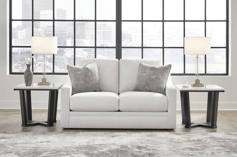 Ashley Furniture Maitelynn loveseat with plush fabric and tufted backrest, featuring cushioned armrests and wooden legs.