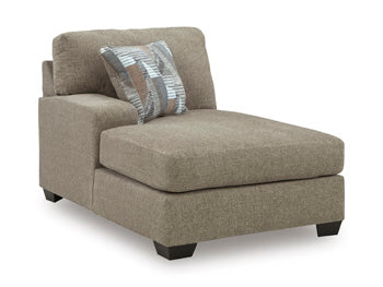 Ashley Furniture Newellen sleeper sectional with chaise, showing a modern beige fabric with plush cushions and a chaise lounge.