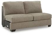 Ashley Furniture Newellen sectional with chaise, showing a modern fabric sofa with a spacious chaise lounge in a living room setting.