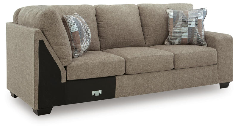 Ashley Furniture Newellen sectional with chaise, beige fabric, and angled view showing plush cushions and modern design.