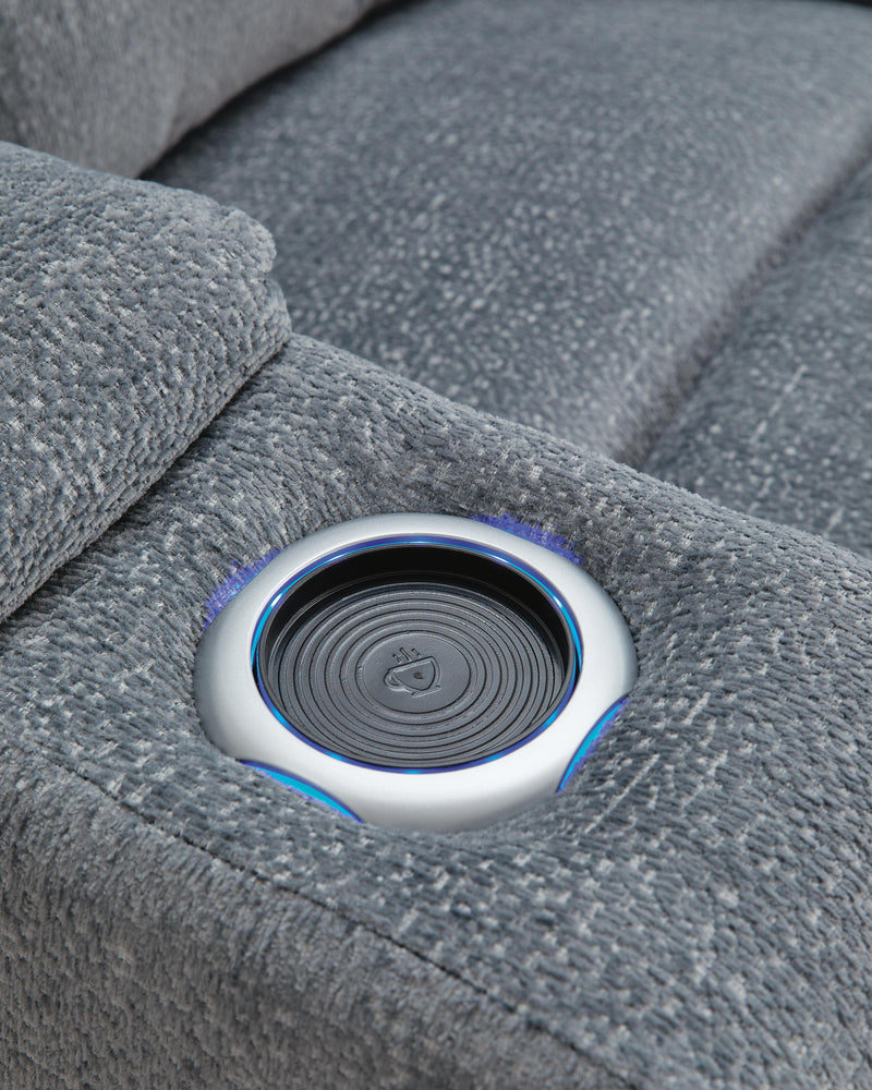 Ashley Furniture Studio Cave power reclining loveseat with built-in console and cup holders, upholstered in plush fabric.