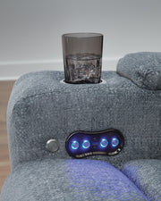 Ashley Furniture Studio Cave Power Reclining Loveseat with Console, gray fabric, plush cushions, and built-in cup holders.