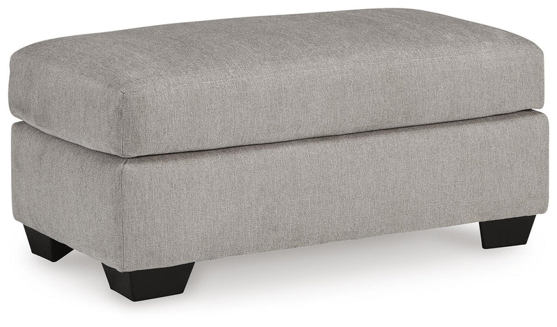 Ashley Furniture Avenal Park Ottoman with cushioned top and wooden legs, shown from an angled view.