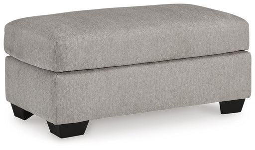 Ashley Furniture Avenal Park Ottoman with cushioned top and wooden legs, shown from an angled view.