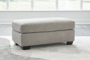 Ashley Furniture Avenal Park Ottoman showing a plush padded top and wooden legs in a cozy living room setting