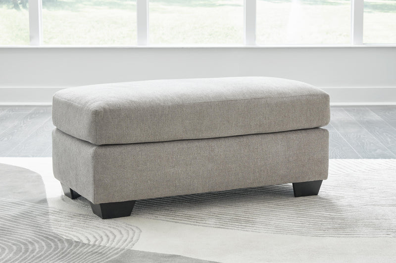 Ashley Furniture Avenal Park Ottoman showing a plush padded top and wooden legs in a cozy living room setting