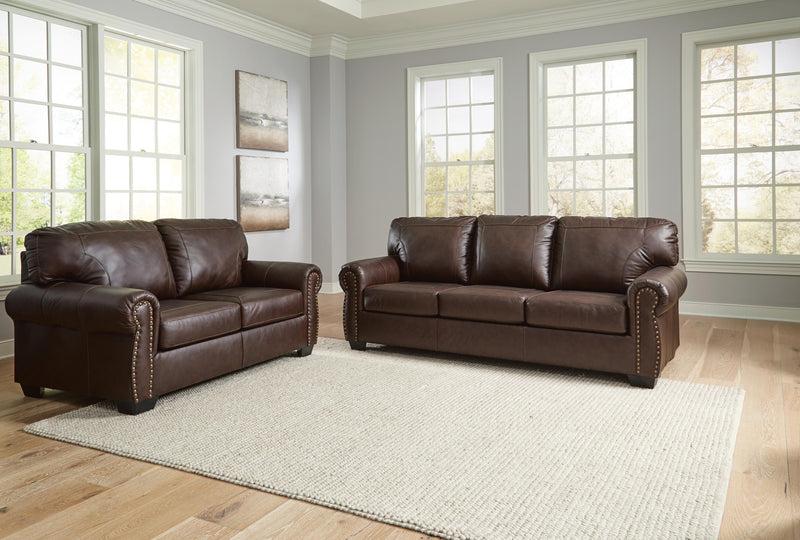 Ashley Furniture Colleton living room set includes a sofa and loveseat with neutral upholstery and wooden legs.