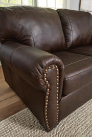 Ashley Furniture Colleton living room set featuring a sofa and armchair with nailhead trim and plush cushions.