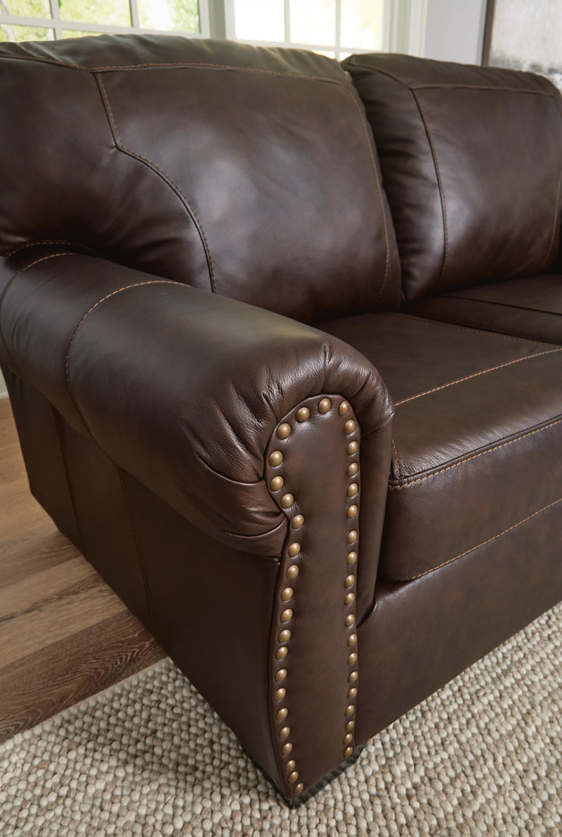 Ashley Furniture Colleton living room set featuring a sofa and armchair with nailhead trim and plush cushions.