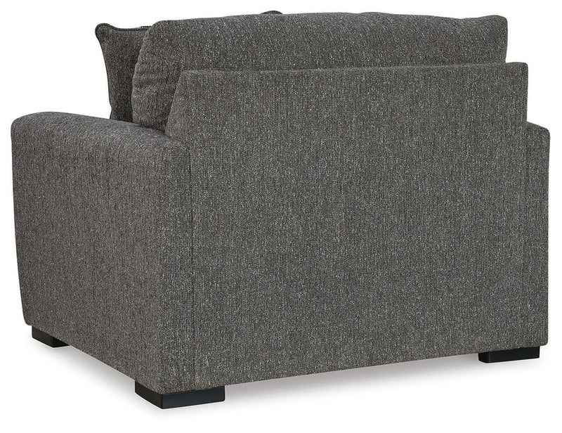 Ashley Furniture Gardiner oversized chair with plush fabric and wide armrests, shown from the back in a cozy living room setting.