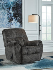 Ashley Furniture Stayfish recliner in a closed position, upholstered in neutral fabric with padded armrests and plush cushioning.