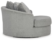 Ashley Furniture Casselbury oversized swivel accent chair in beige fabric, shown from the side with plush cushioning and a rounded back.